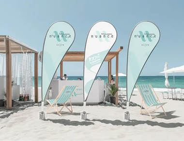 NUANCE branded beach flags and deck chairs on the sand
